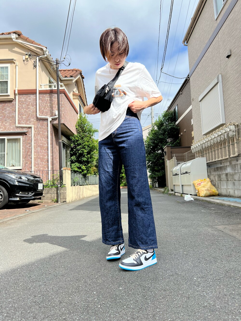 ホワイト系のTシャツ/カットソー、ブルー系のデニムパンツ、ブルー系のスニーカーを着用したレディースの秋コーディネートの2枚目の写真
