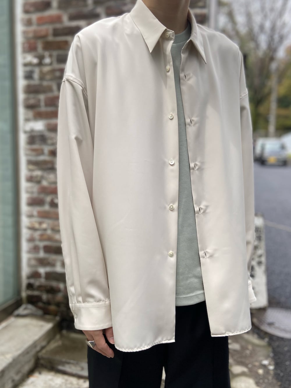 ベージュ系のシャツ/ブラウス、グリーン系のTシャツ/カットソー、ブラック系のスラックスを着用したメンズの春コーディネートの2枚目の写真