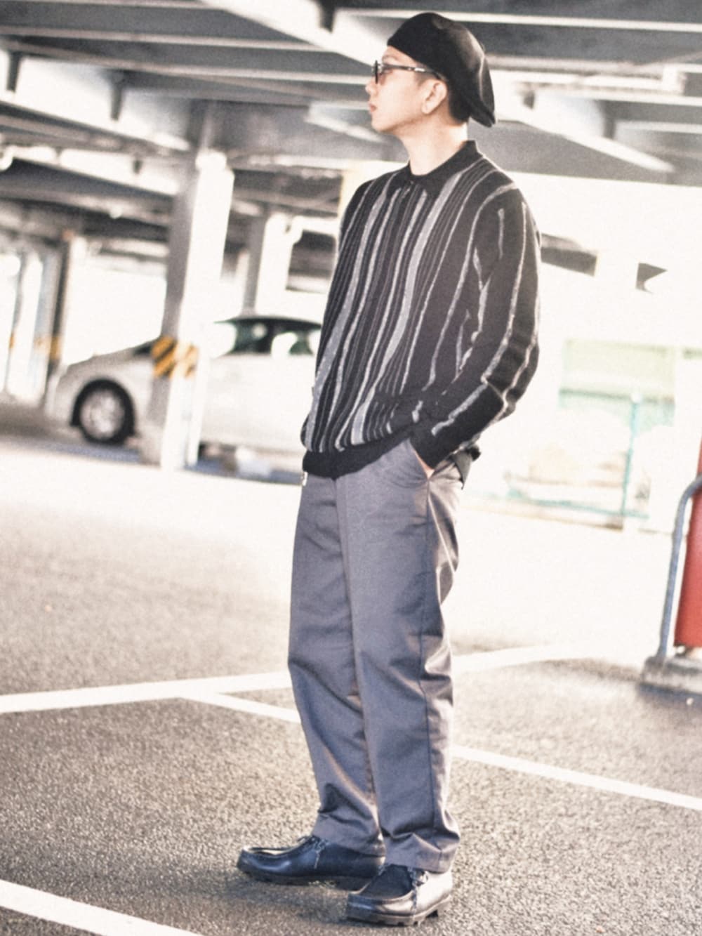 ブラック系のニット/セーター、グレー系のチノパンツ、ブラック系のキャスケットを着用したメンズの秋コーディネートの2枚目の写真