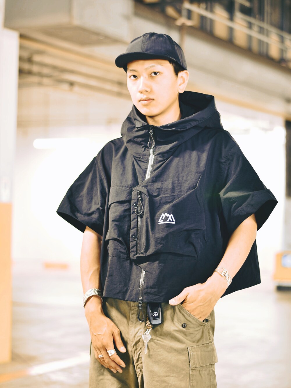 ブラック系のシャツ/ブラウス、ブラック系のスニーカー、グリーン系のカーゴパンツを着用したメンズの夏コーディネートの2枚目の写真