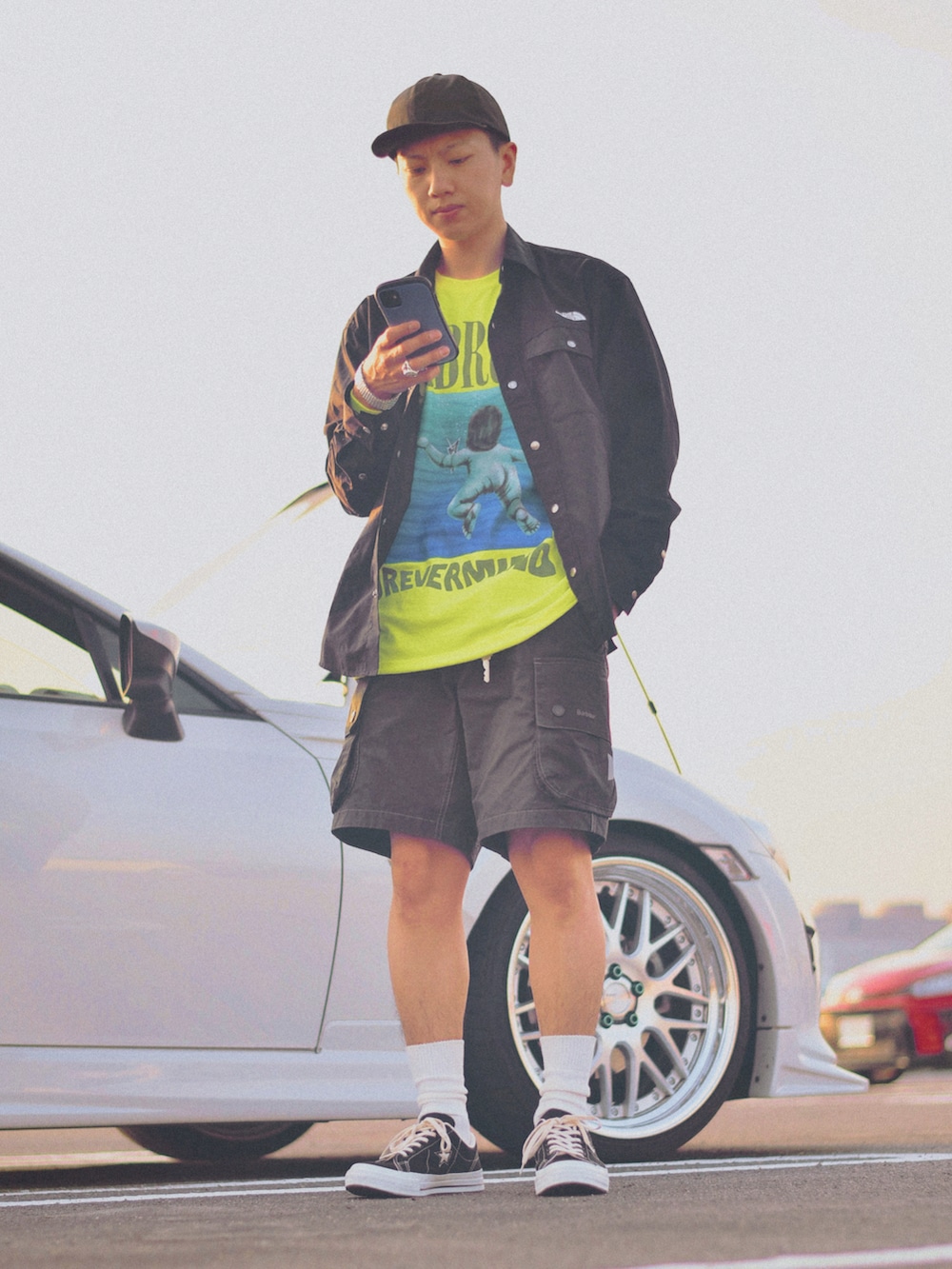 イエロー系のTシャツ/カットソー、グリーン系のパンツ、ブラック系のスニーカーを着用したメンズの春コーディネートの2枚目の写真