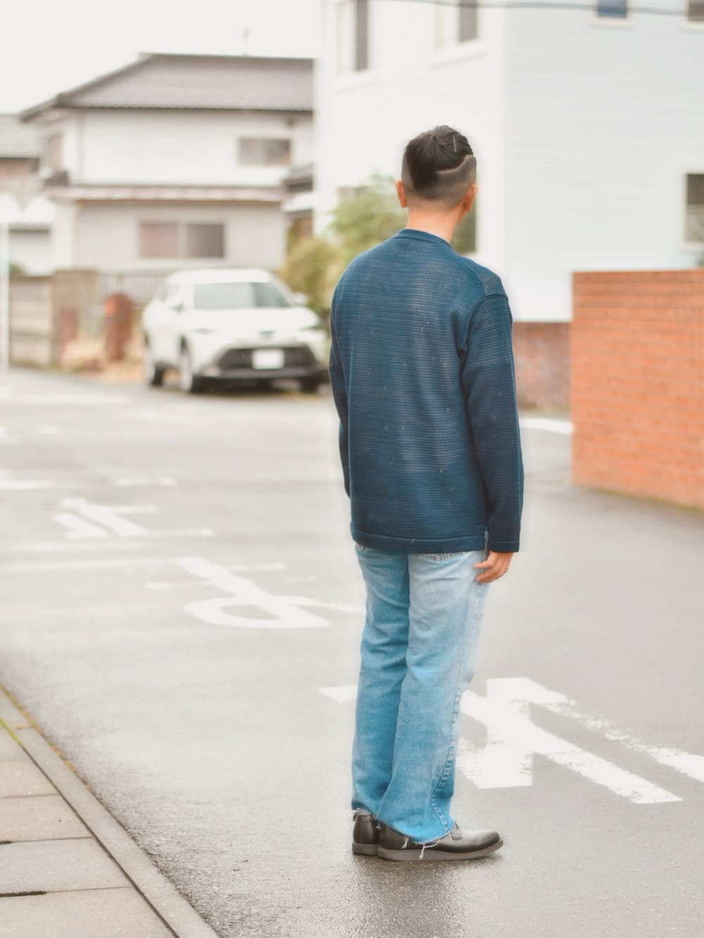 ブラック系のブーツ、ブルー系のデニムパンツ、ブラック系のニット/セーターを着用したメンズの秋コーディネートの2枚目の写真