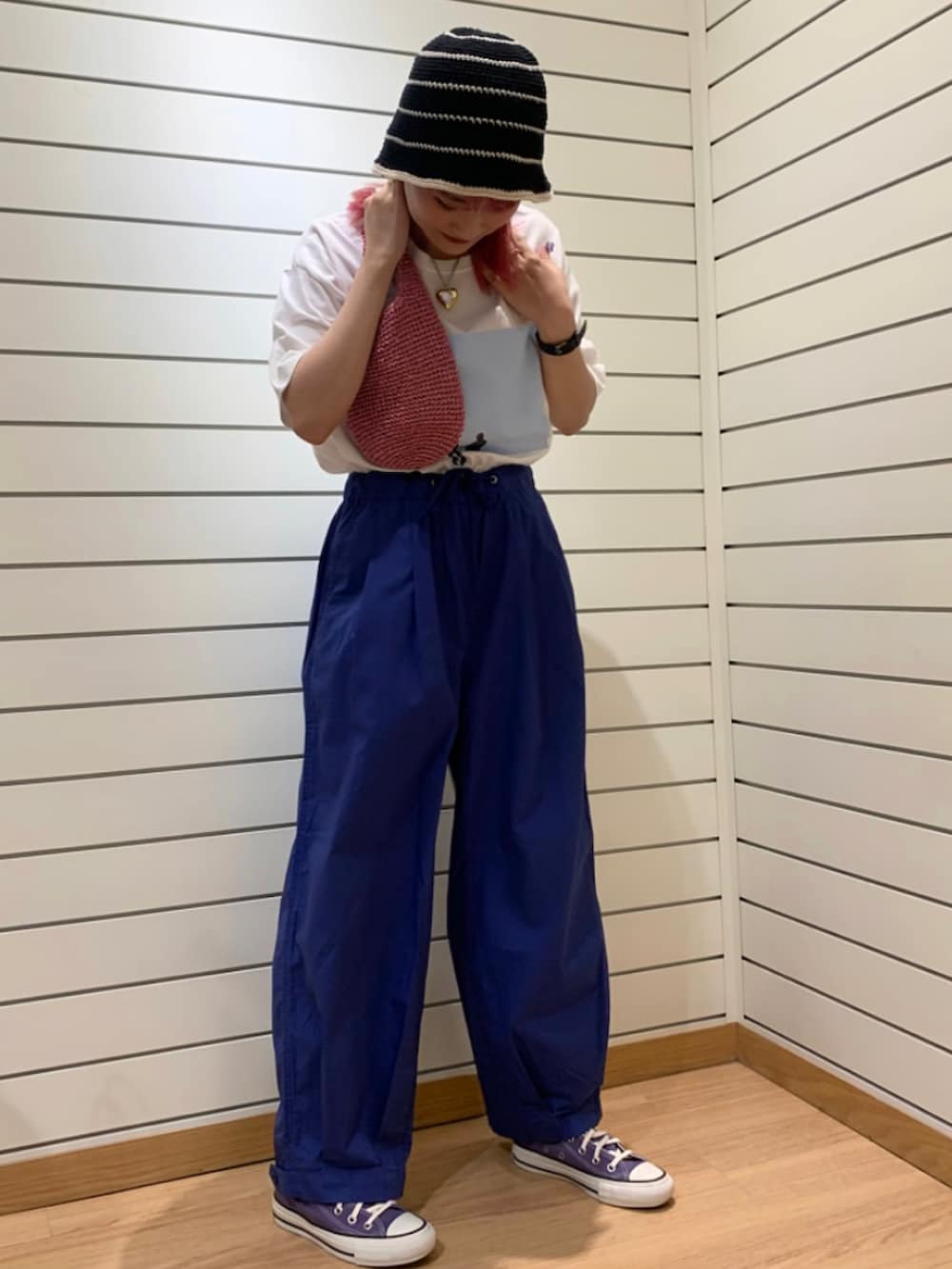 ピンク系のトートバッグ、ブルー系のその他パンツ、パープル系のスニーカーを着用したレディースの春コーディネートの2枚目の写真