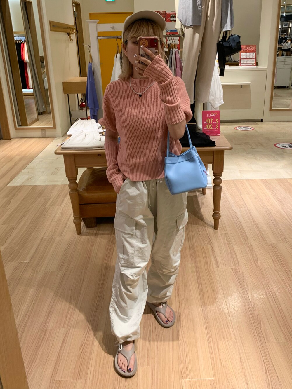 ピンク系のニット/セーター、ホワイト系のカーゴパンツを着用したレディースの夏コーディネートの2枚目の写真