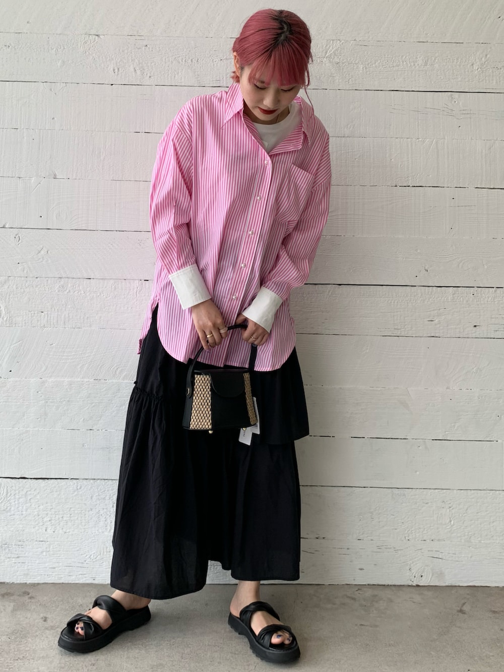 ピンク系のシャツ/ブラウス、ブラック系のスカート、ブラック系のサンダルを着用したレディースの春コーディネートの3枚目の写真