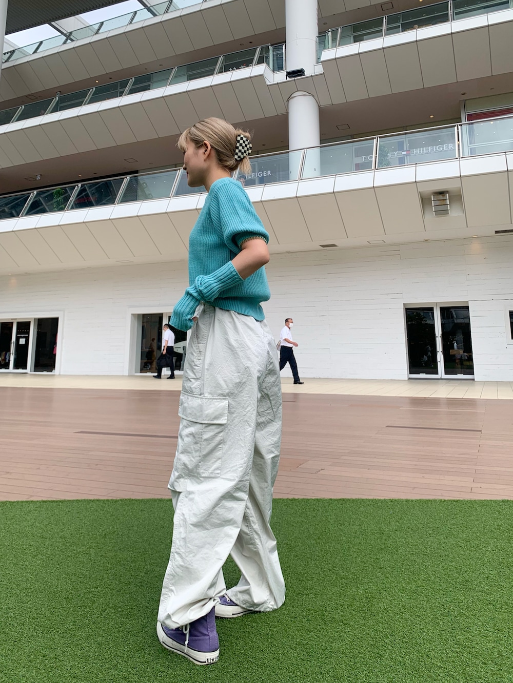 ブルー系のニット/セーター、パープル系のスニーカー、ホワイト系のカーゴパンツを着用したレディースの秋コーディネートの2枚目の写真