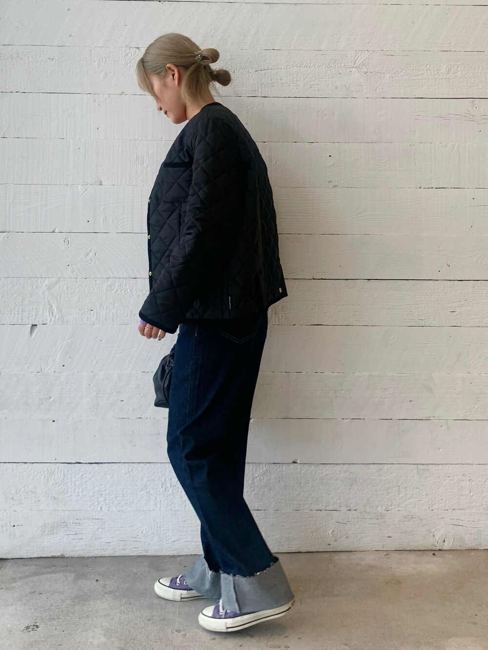 レッド系のニット/セーター、ブルー系のデニムパンツを着用したレディースの秋コーディネートの2枚目の写真