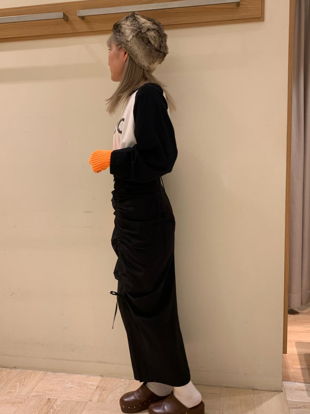 ブラック系のスカートを着用したレディースの秋コーディネートの2枚目の写真