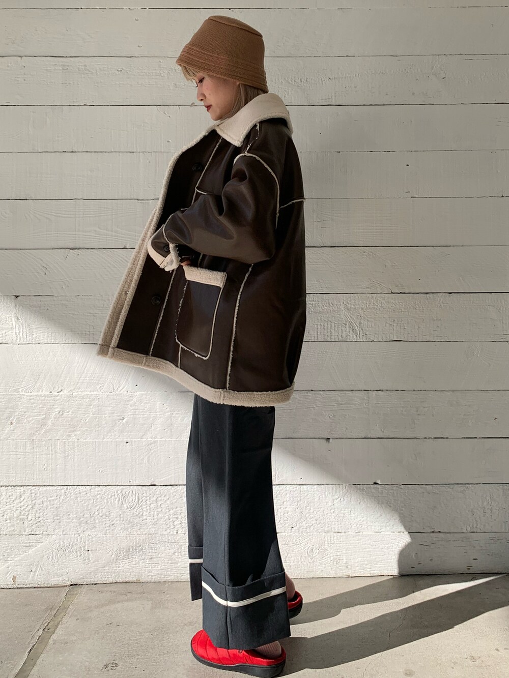 グレー系のスラックス、レッド系のサンダルを着用したレディースの冬コーディネートの3枚目の写真