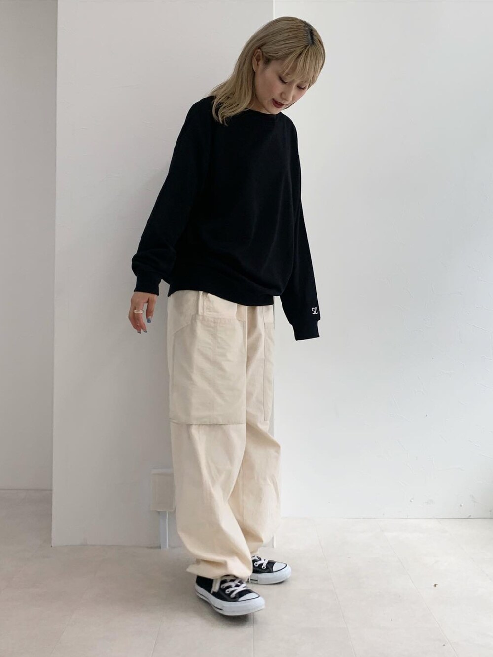 ブラック系のスウェット、ホワイト系のカーゴパンツを着用したレディースの秋コーディネートの2枚目の写真