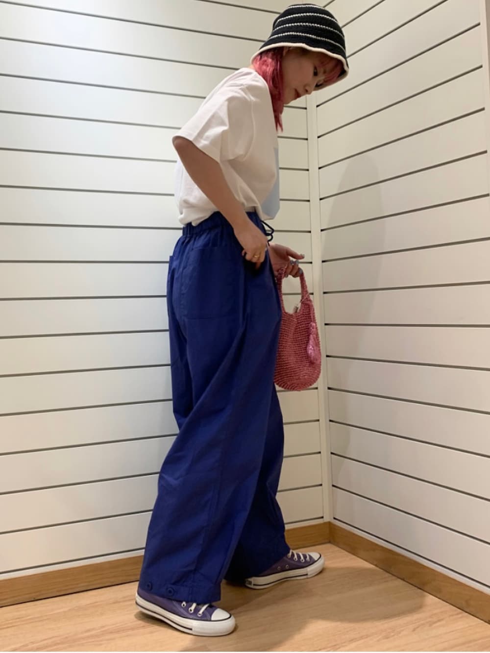 ピンク系のトートバッグ、ブルー系のその他パンツ、パープル系のスニーカーを着用したレディースの春コーディネートの3枚目の写真