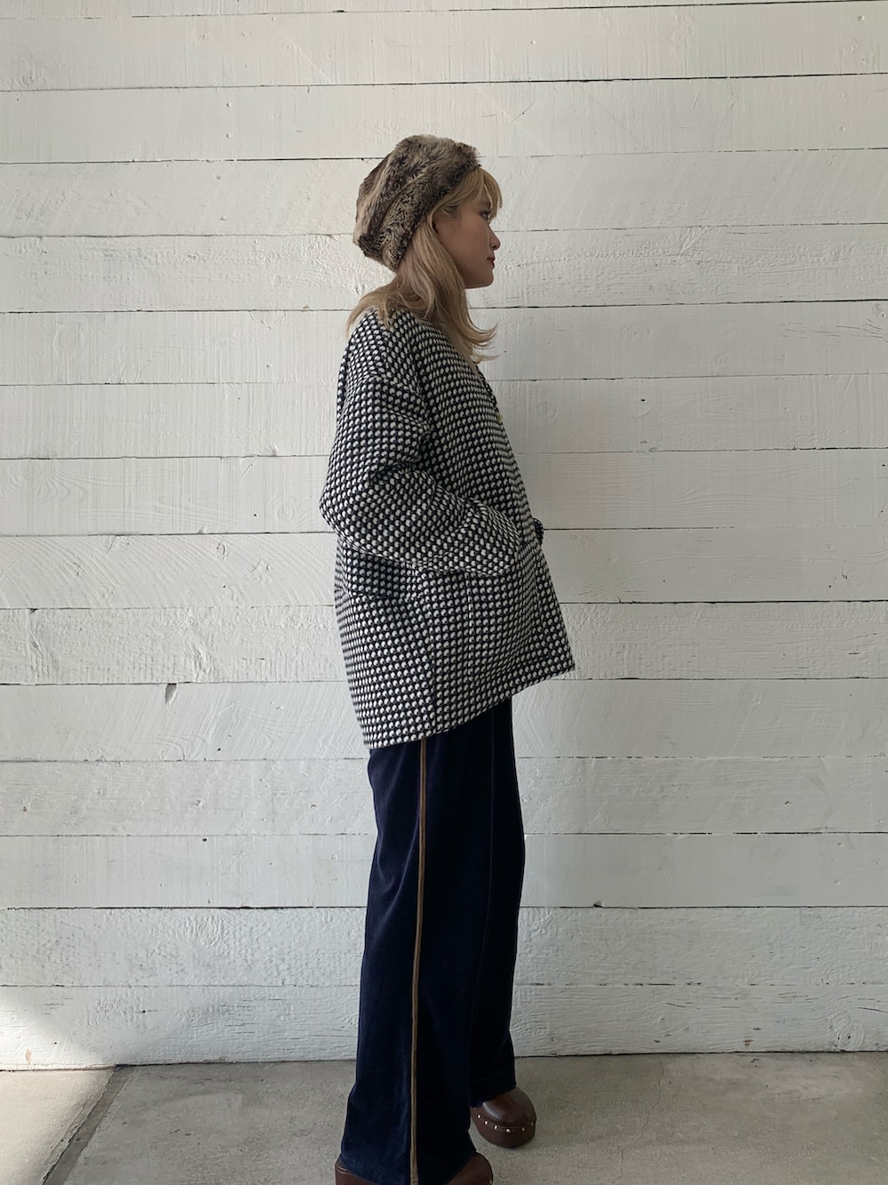 ブラック系のノーカラーコートを着用したレディースの秋コーディネートの3枚目の写真