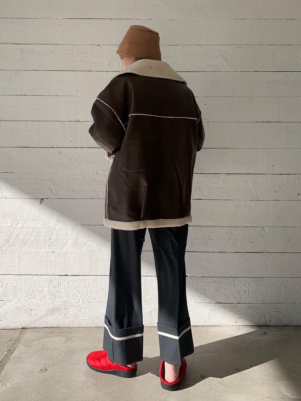 グレー系のスラックス、レッド系のサンダルを着用したレディースの冬コーディネートの2枚目の写真