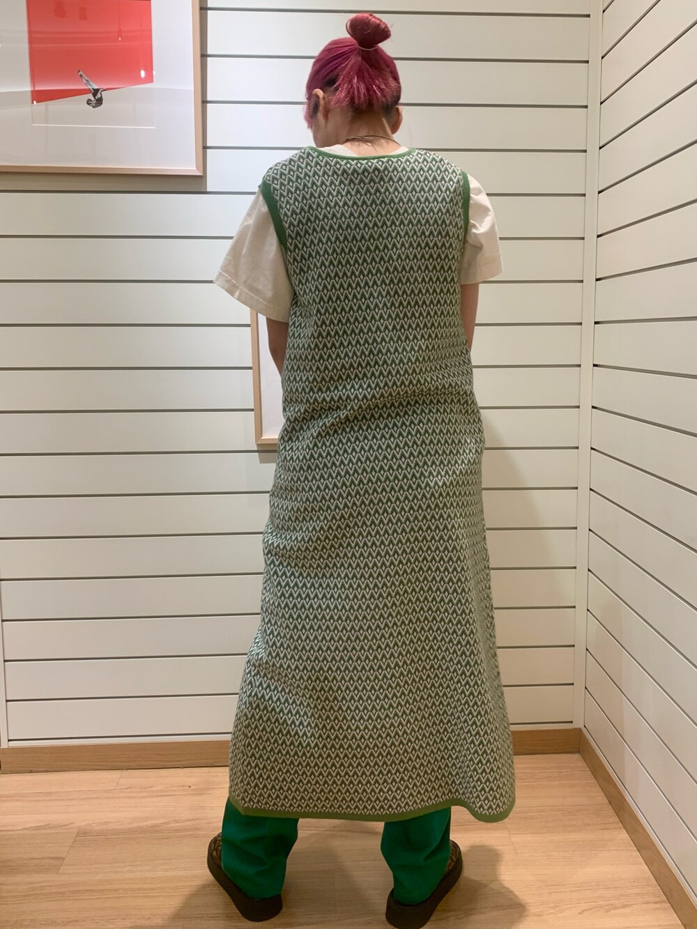 グリーン系のベスト、グリーン系のチノパンツを着用したレディースの春コーディネートの3枚目の写真