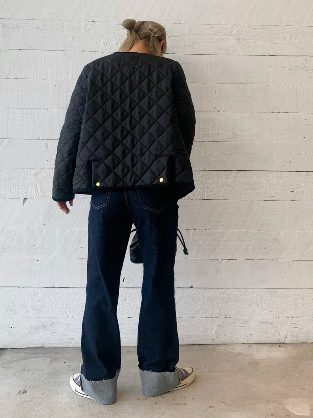 レッド系のニット/セーター、ブルー系のデニムパンツを着用したレディースの秋コーディネートの3枚目の写真