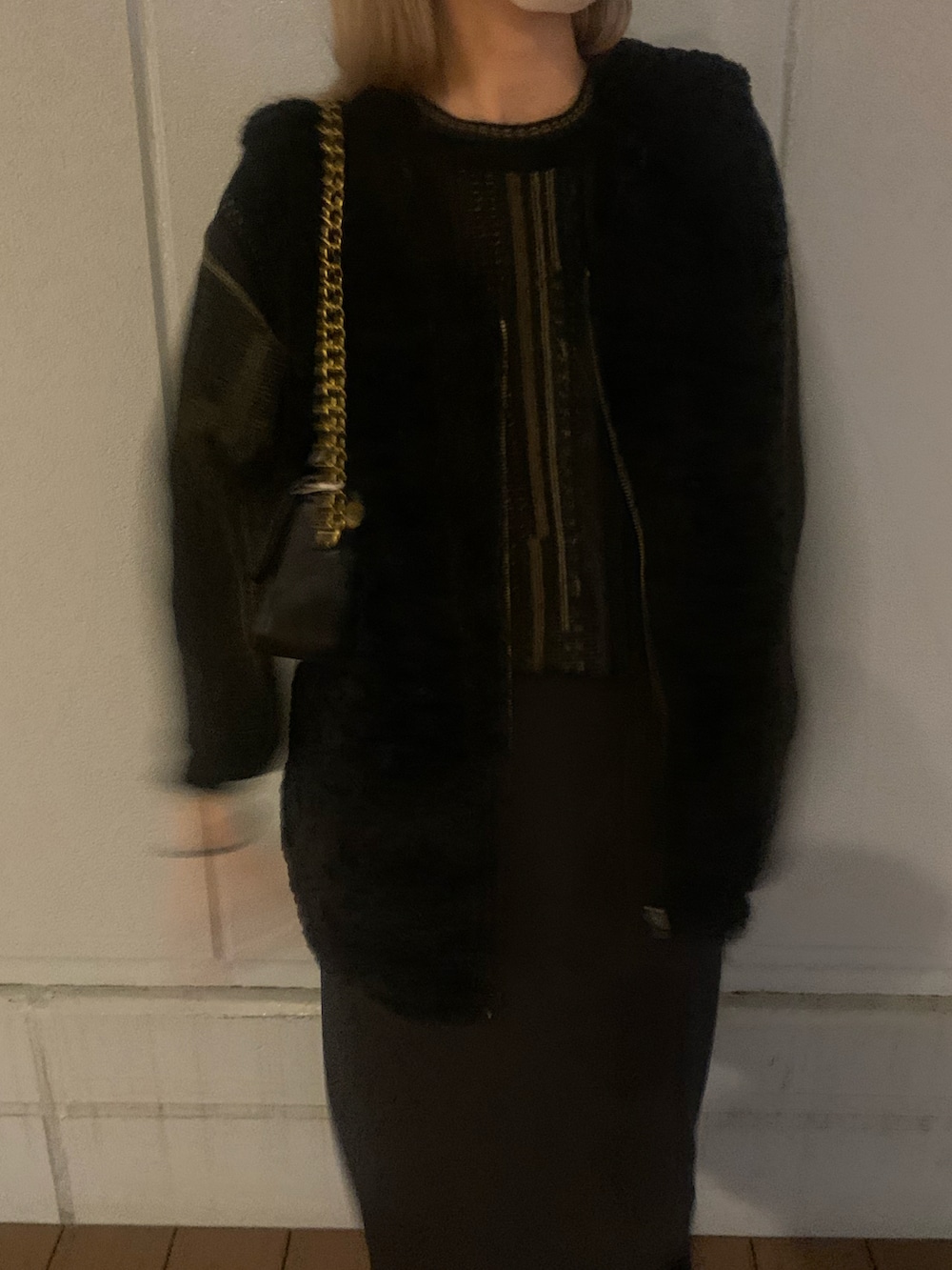 ブラック系のベスト、ブラック系のニット/セーター、ブラック系のショルダーバッグを着用したレディースの秋コーディネートの3枚目の写真