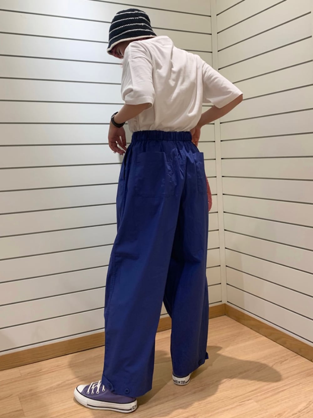 ピンク系のトートバッグ、ブルー系のその他パンツ、パープル系のスニーカーを着用したレディースの春コーディネートの4枚目の写真