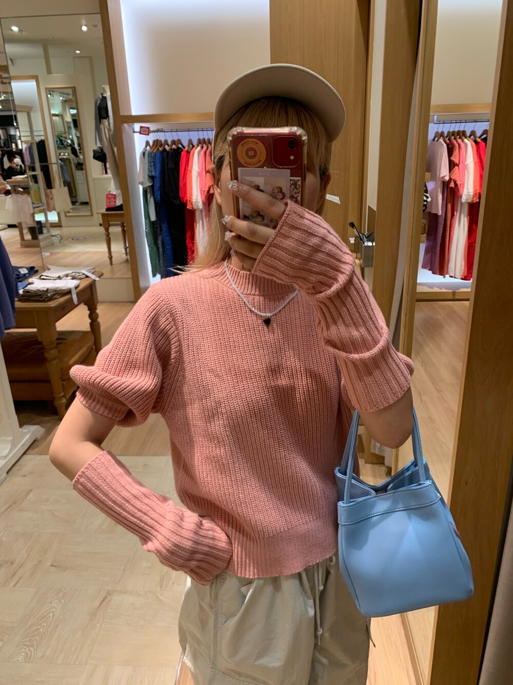 ピンク系のニット/セーター、ホワイト系のカーゴパンツを着用したレディースの夏コーディネートの3枚目の写真