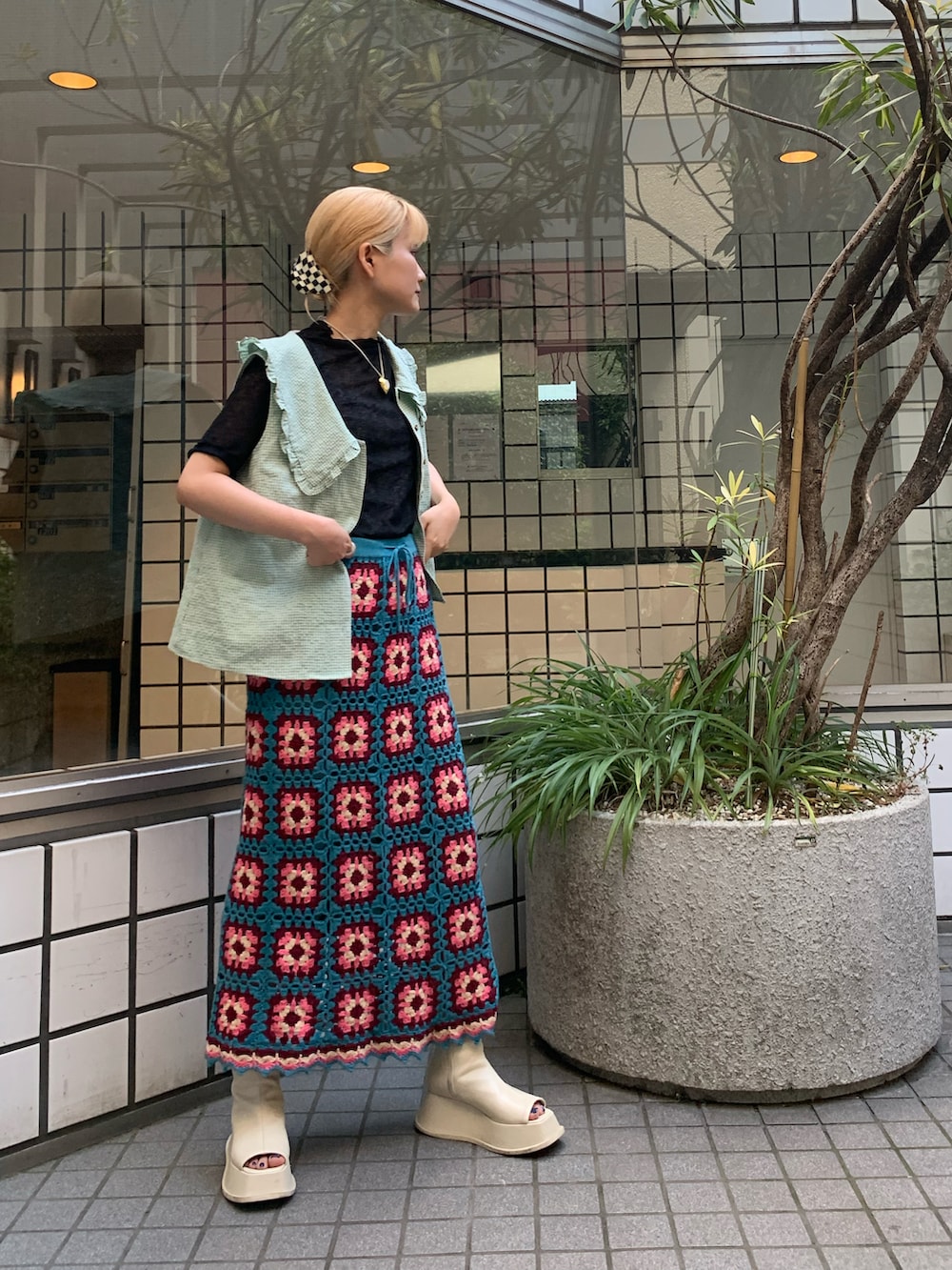 ブルー系のスカート、ホワイト系のスリッポン、グリーン系のシャツ/ブラウスを着用したレディースの夏コーディネートの2枚目の写真