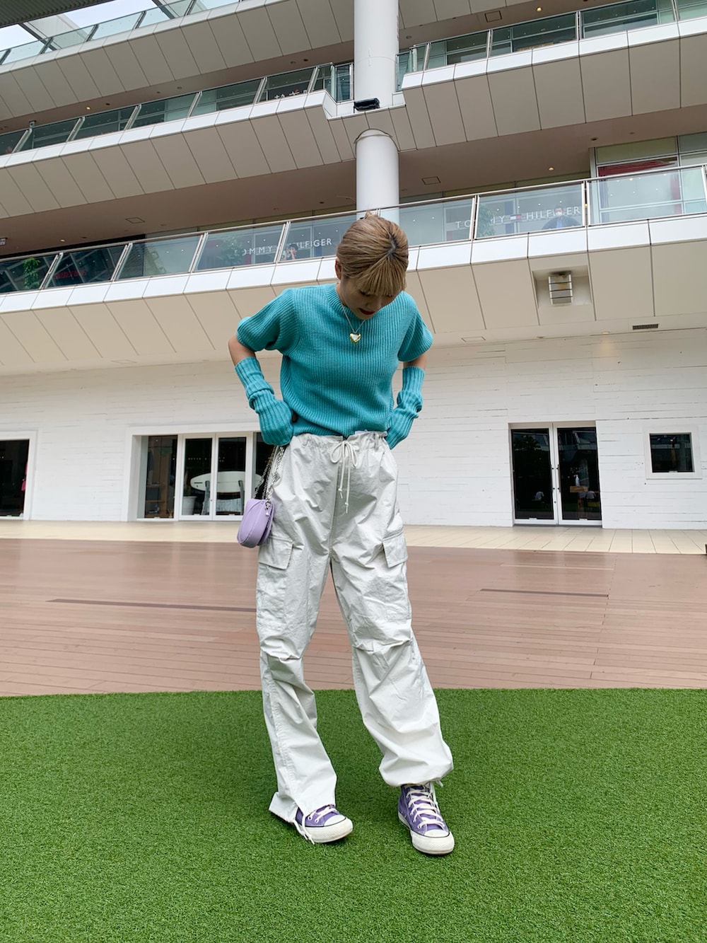 ブルー系のニット/セーター、パープル系のスニーカー、ホワイト系のカーゴパンツを着用したレディースの秋コーディネートの3枚目の写真