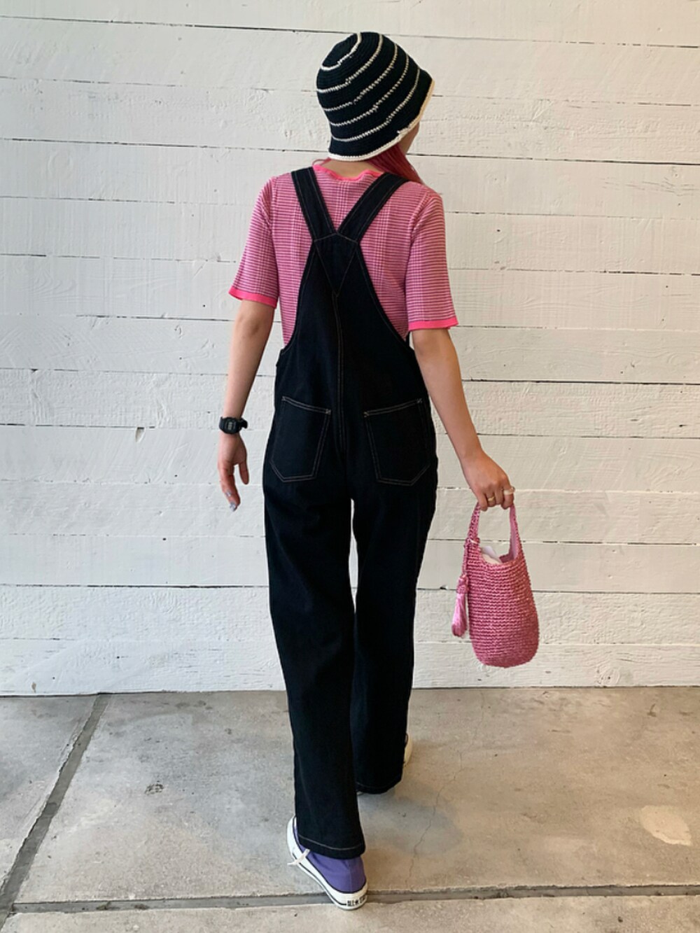 ピンク系のトートバッグ、パープル系のスニーカー、ブラック系のサロペット/オーバーオールを着用したレディースの春コーディネートの3枚目の写真