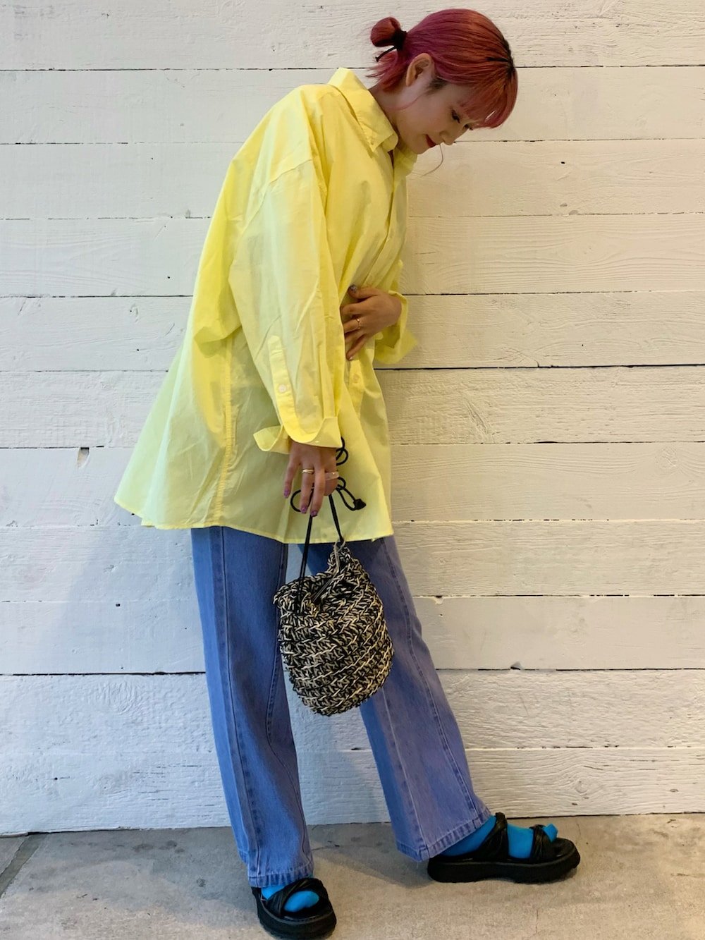 イエロー系のシャツ/ブラウス、ブルー系のデニムパンツ、ブラック系のショルダーバッグを着用したレディースの春コーディネートの2枚目の写真