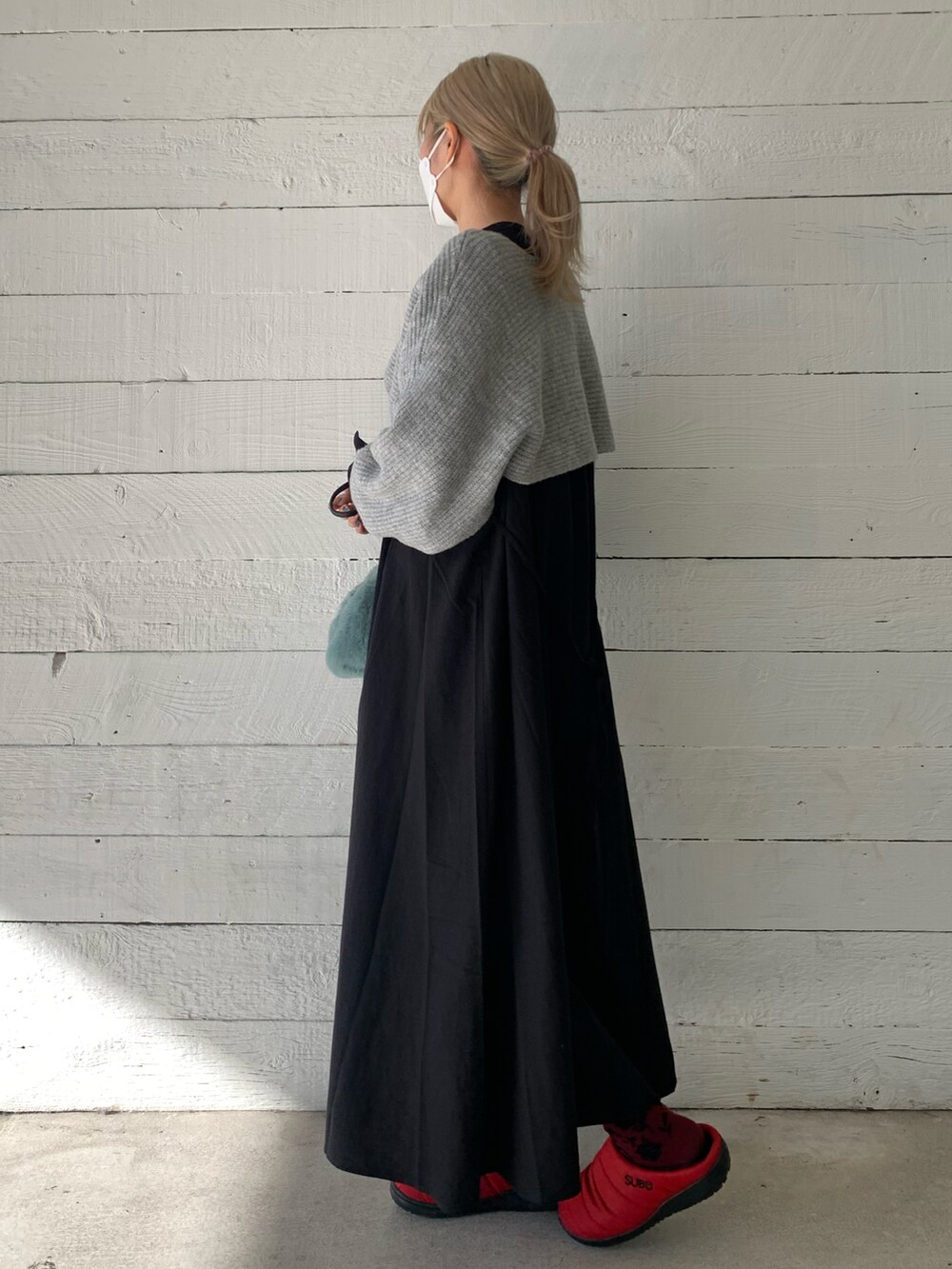 ブラック系のワンピース、グリーン系のショルダーバッグ、レッド系のサンダルを着用したレディースの秋コーディネートの3枚目の写真