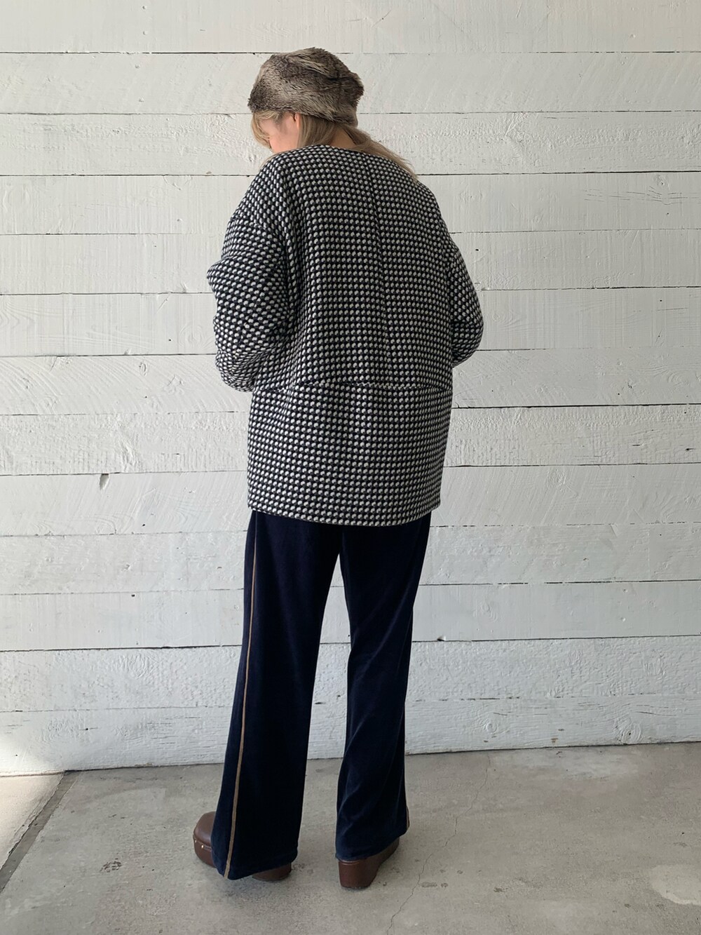 ブラック系のノーカラーコートを着用したレディースの秋コーディネートの2枚目の写真