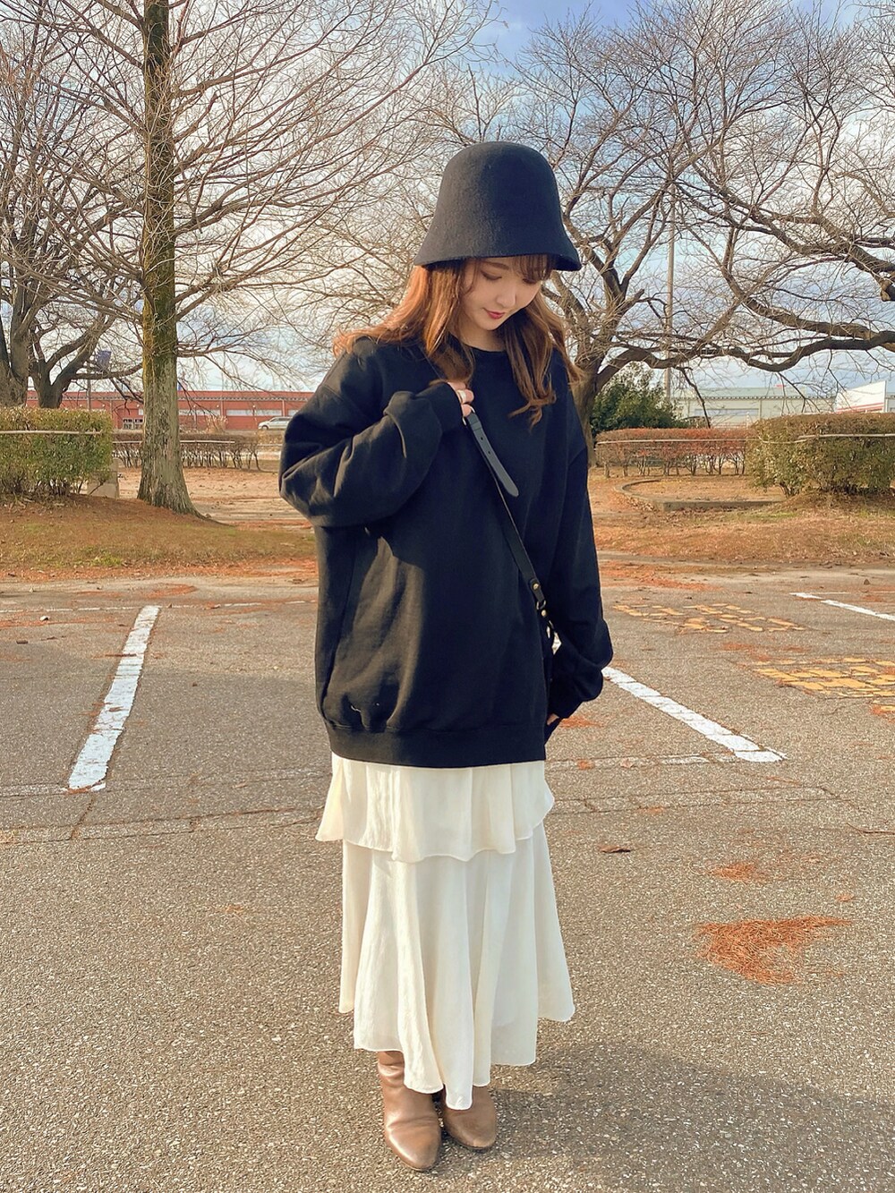 ブラック系のスウェットを着用したレディースの冬コーディネートの2枚目の写真