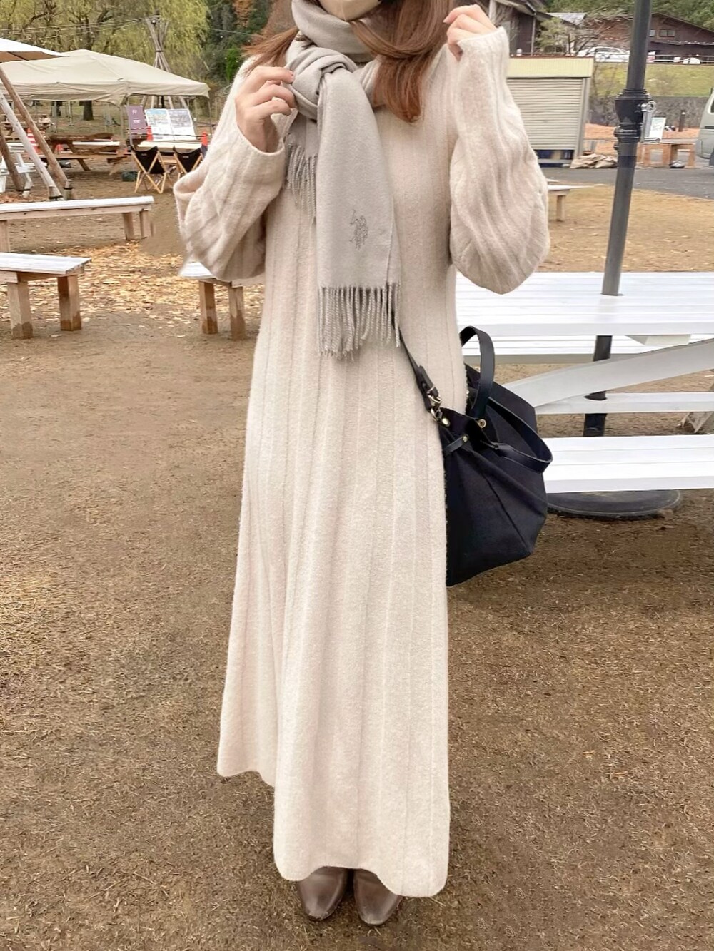ベージュ系のワンピースを着用したレディースの冬コーディネートの2枚目の写真