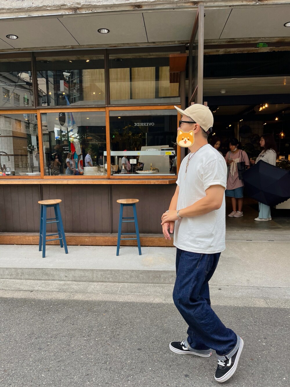 ホワイト系のTシャツ/カットソー、ブラック系のスニーカー、ブルー系のデニムパンツを着用したメンズの秋コーディネートの2枚目の写真