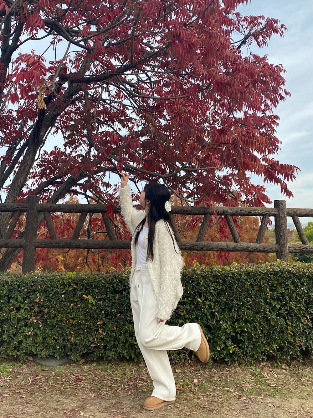 ホワイト系のスウェットパンツ、ブラウン系のブーツ、ホワイト系のバックパック/リュックを着用したレディースの冬コーディネートの2枚目の写真