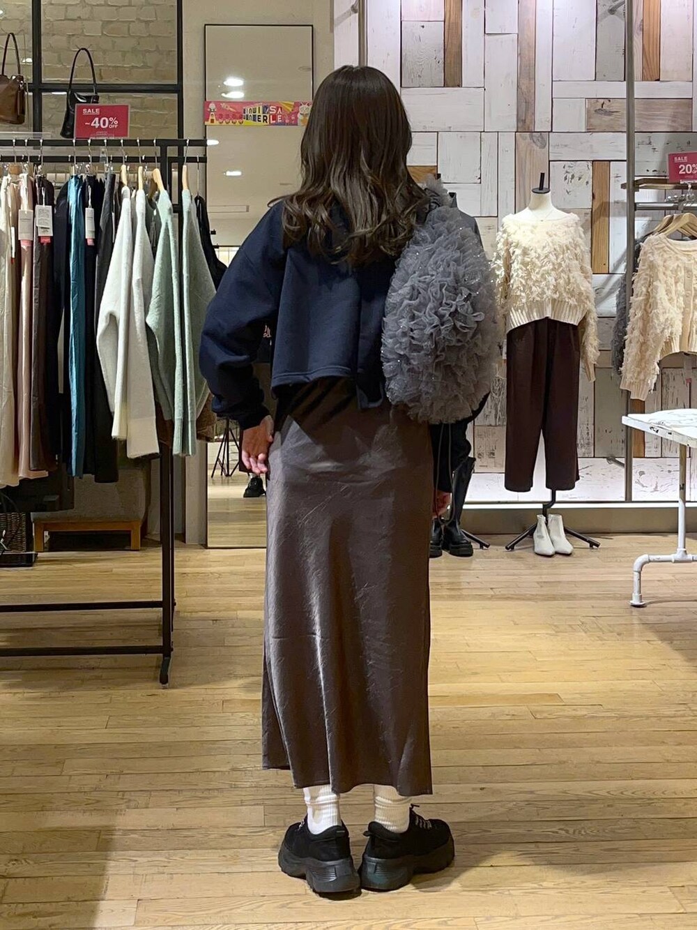 グレー系のスカート、ブラック系のモカシン/デッキシューズ、グレー系のショルダーバッグを着用したレディースの冬コーディネートの3枚目の写真