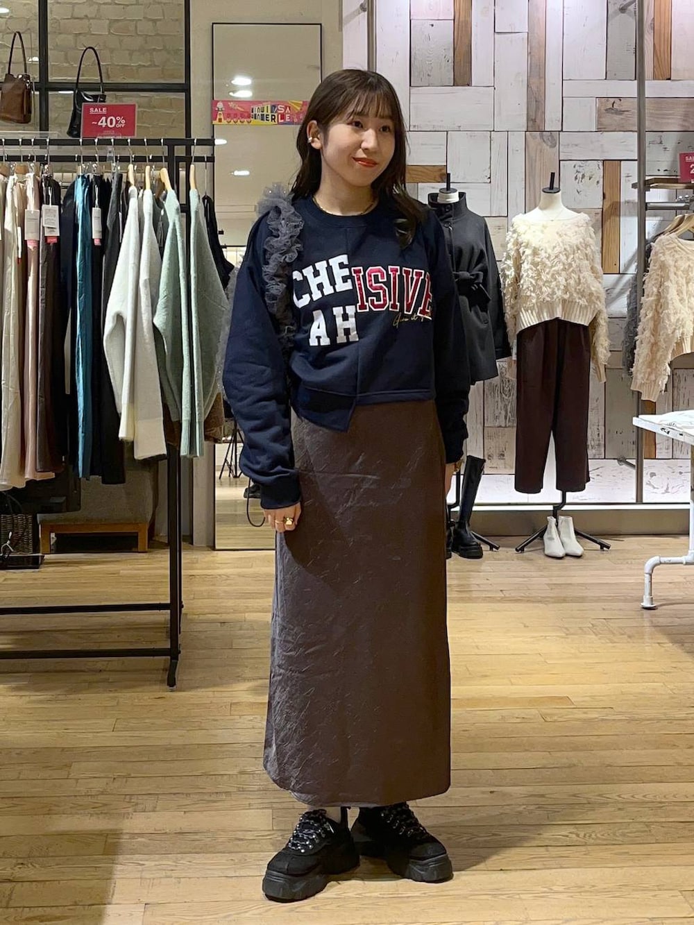 グレー系のスカート、ブラック系のモカシン/デッキシューズ、グレー系のショルダーバッグを着用したレディースの冬コーディネートの4枚目の写真