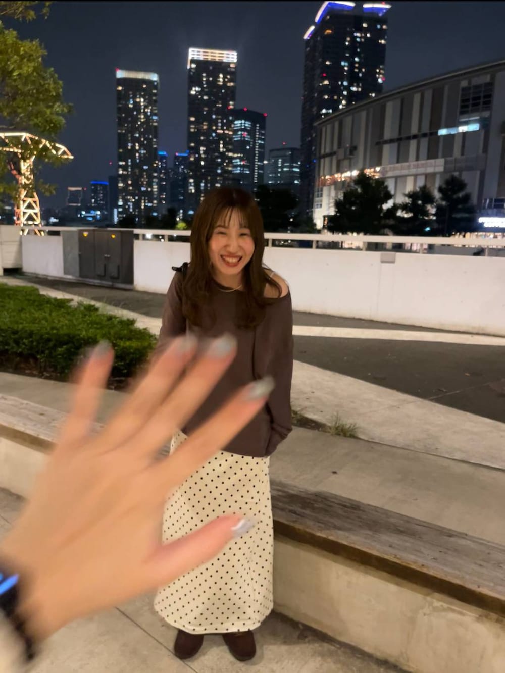 ホワイト系のスカート、ブラウン系のスニーカー、ブラック系のボストンバッグを着用したレディースの秋コーディネートの4枚目の写真