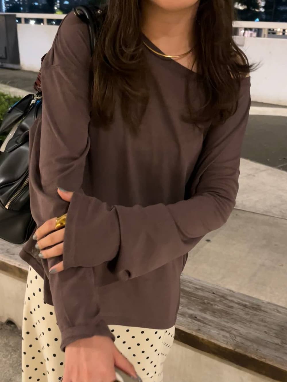 ホワイト系のスカート、ブラウン系のスニーカー、ブラック系のボストンバッグを着用したレディースの秋コーディネートの2枚目の写真