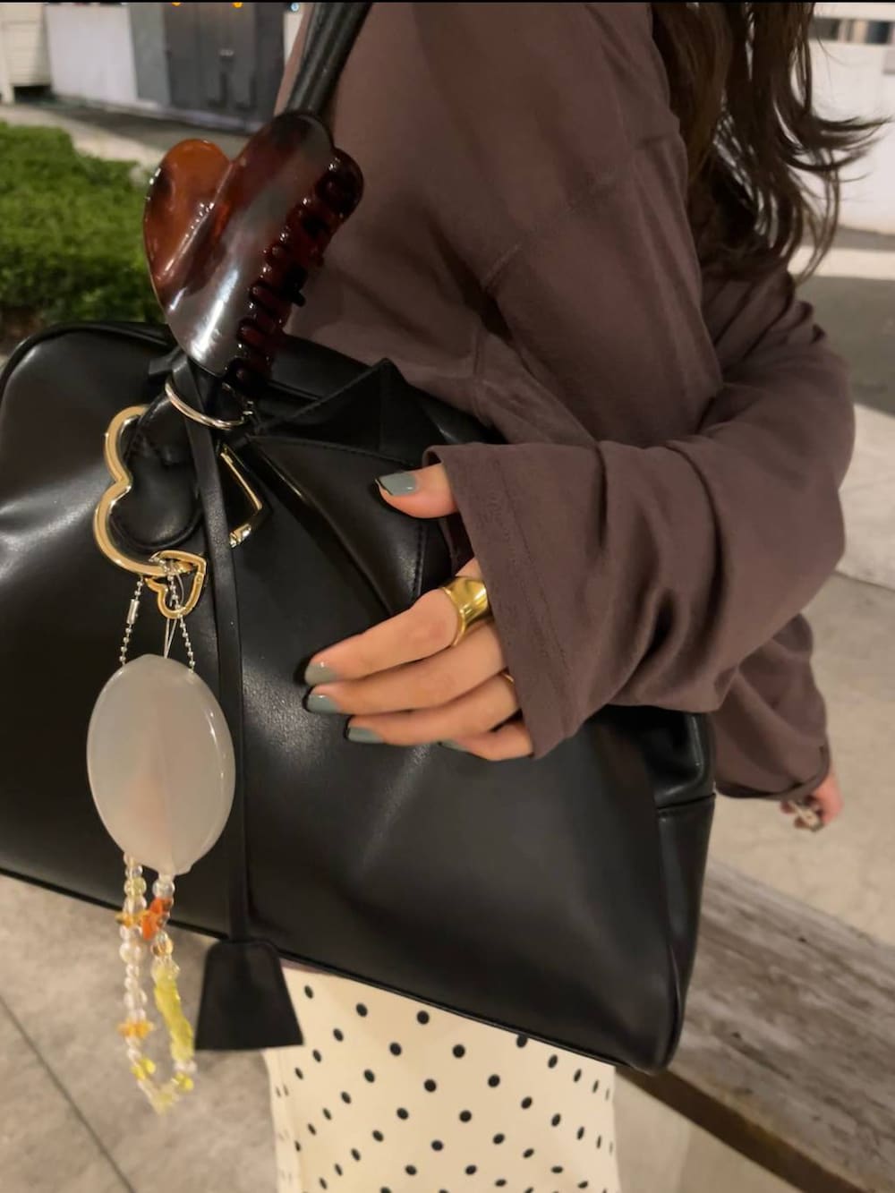 ホワイト系のスカート、ブラウン系のスニーカー、ブラック系のボストンバッグを着用したレディースの秋コーディネートの5枚目の写真