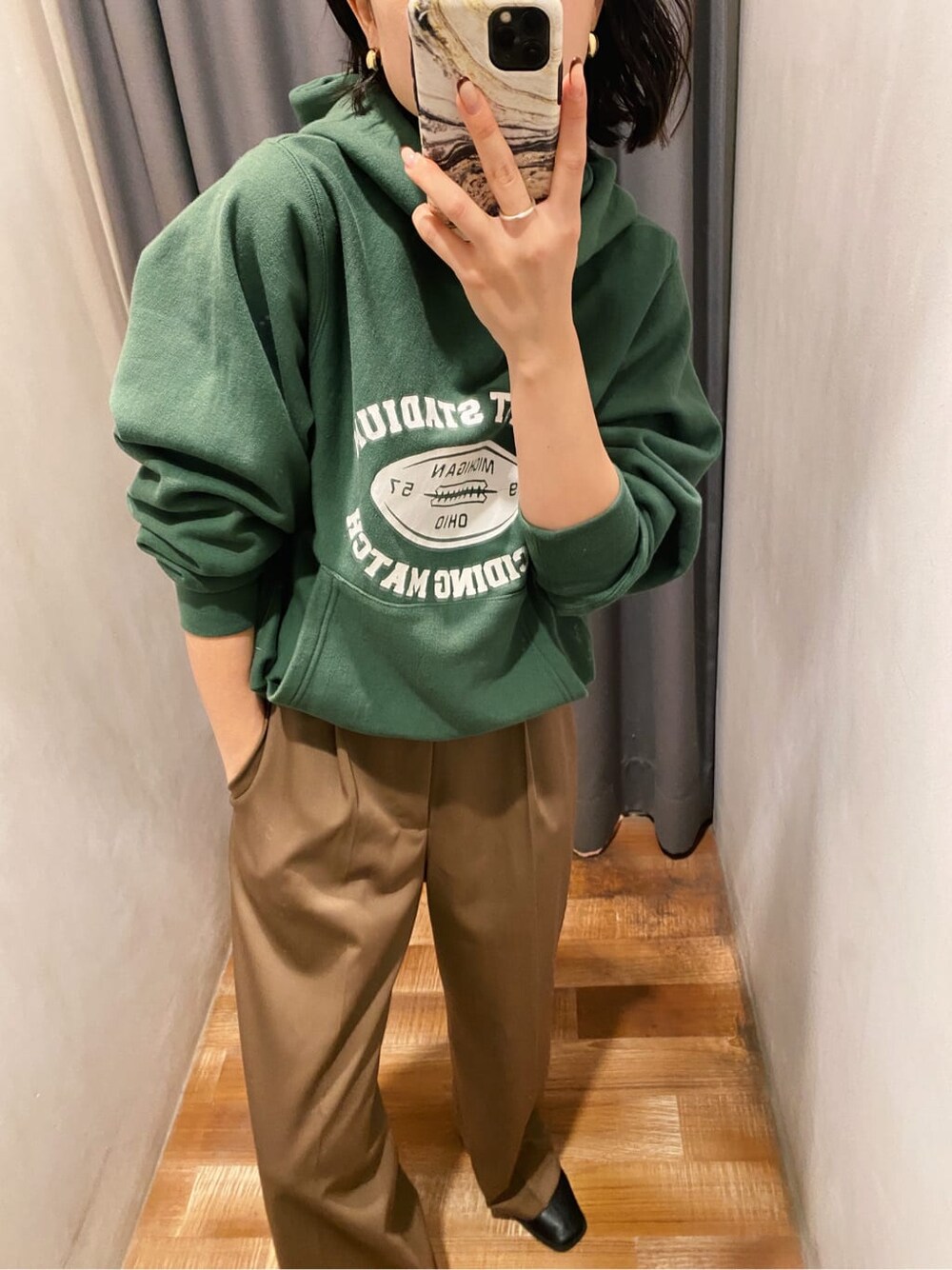 グリーン系のパーカー、ブラウン系のその他パンツを着用したレディースの冬コーディネートの5枚目の写真