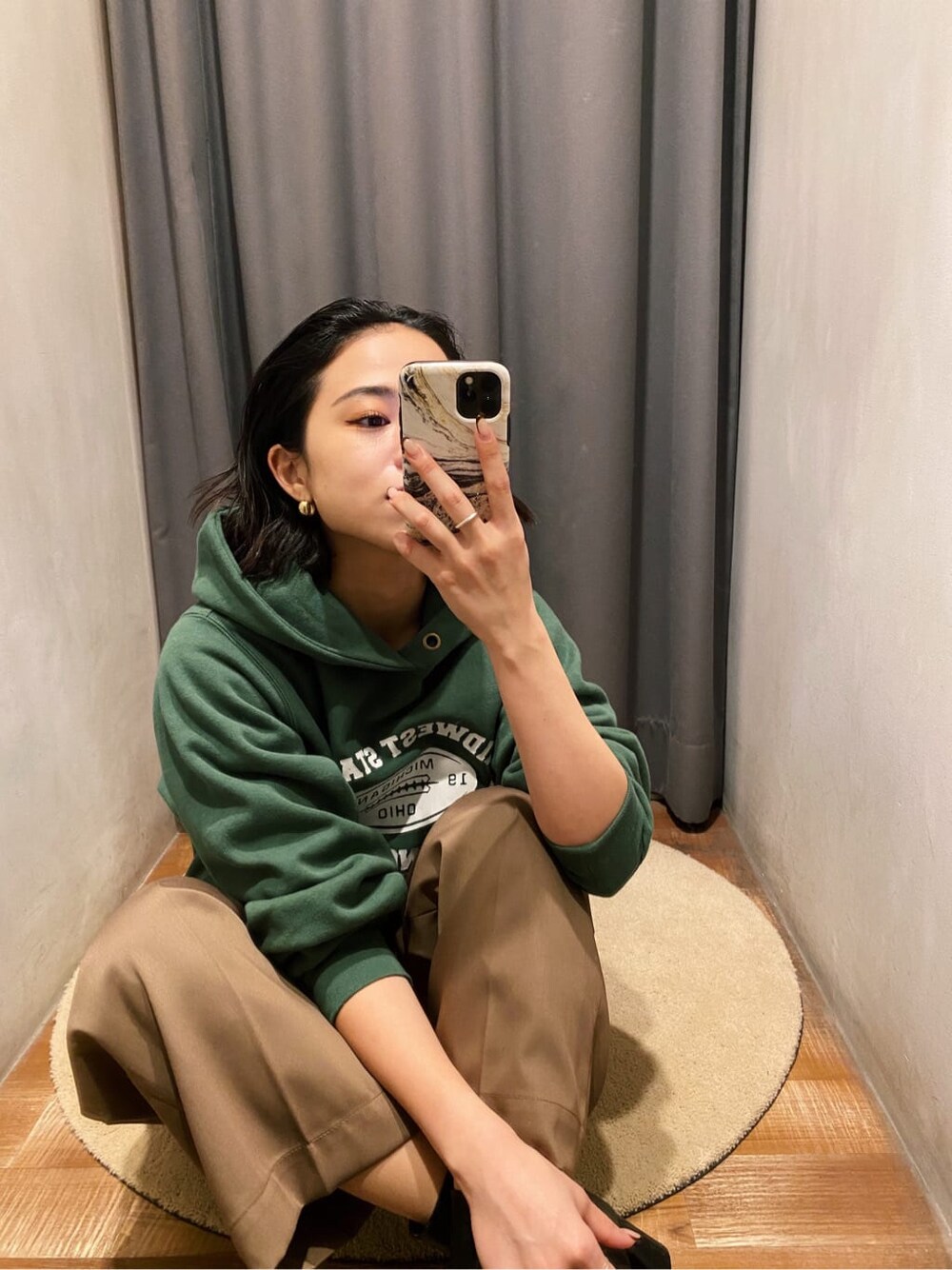 グリーン系のパーカー、ブラウン系のその他パンツを着用したレディースの冬コーディネートの3枚目の写真