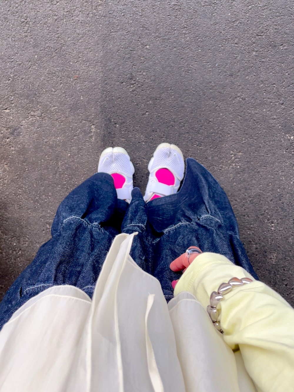 イエロー系のTシャツ/カットソー、ブルー系のデニムスカート、ベージュ系のショルダーバッグを着用したレディースの秋コーディネートの2枚目の写真