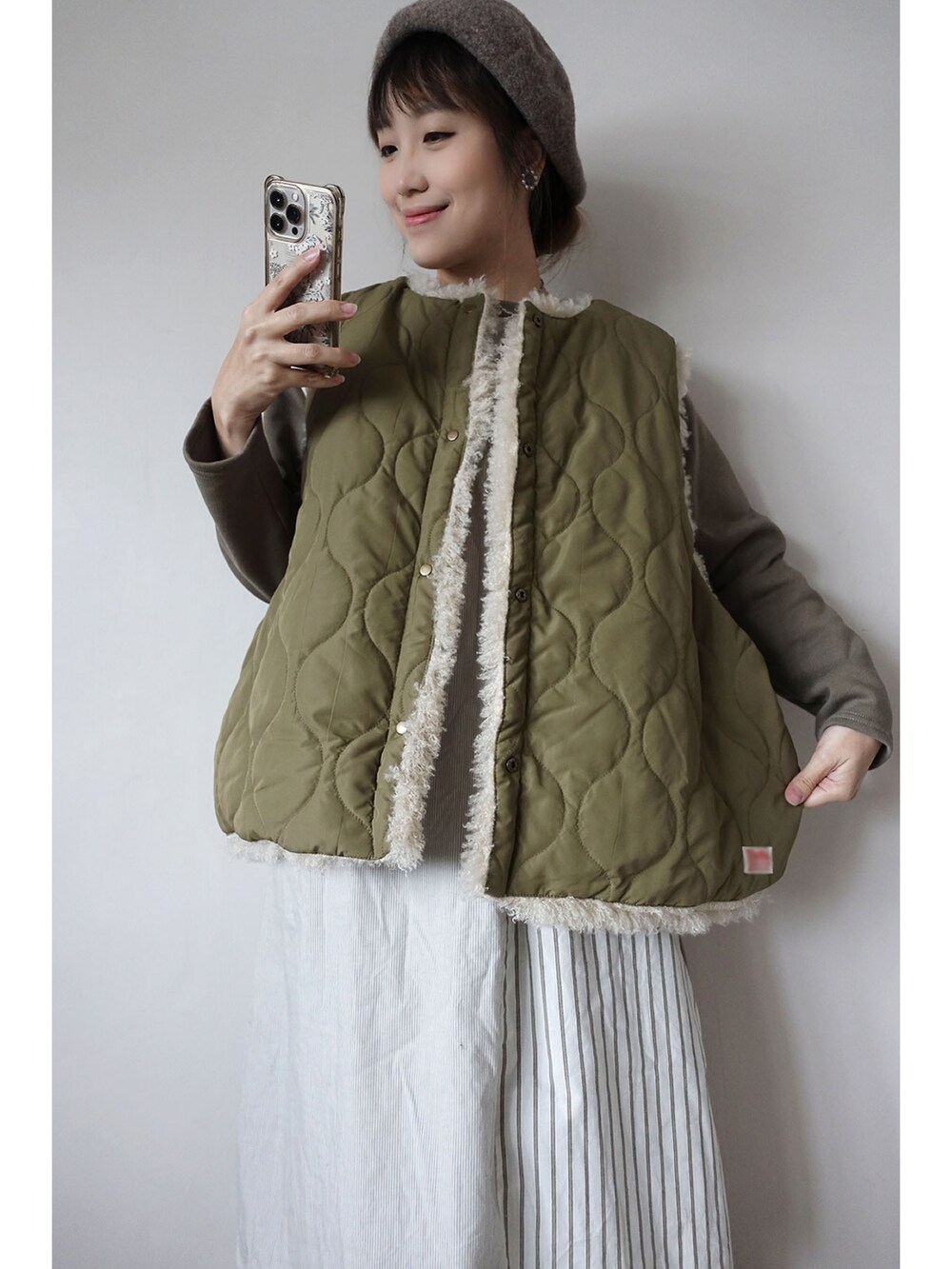 グリーン系のその他アウター、グリーン系のワンピース、グリーン系のチノパンツを着用したレディースの冬コーディネートの2枚目の写真