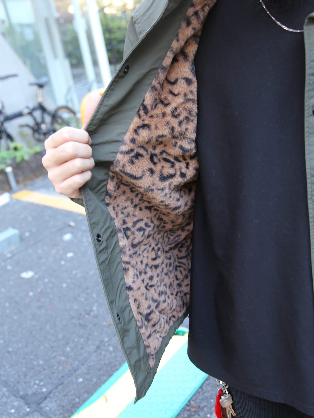 ブラック系のスラックス、グリーン系のブルゾン、ブラック系のキャップを着用したメンズの秋コーディネートの3枚目の写真