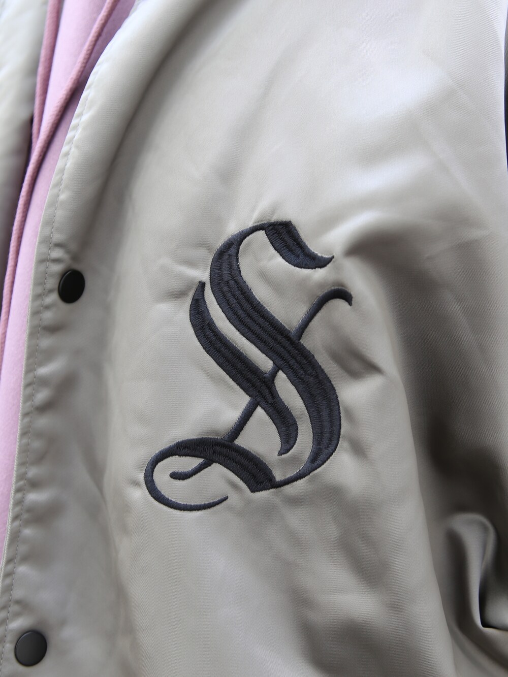 ブラック系のスラックス、グレー系のスタジャン、パープル系のパーカーを着用したメンズの秋コーディネートの3枚目の写真