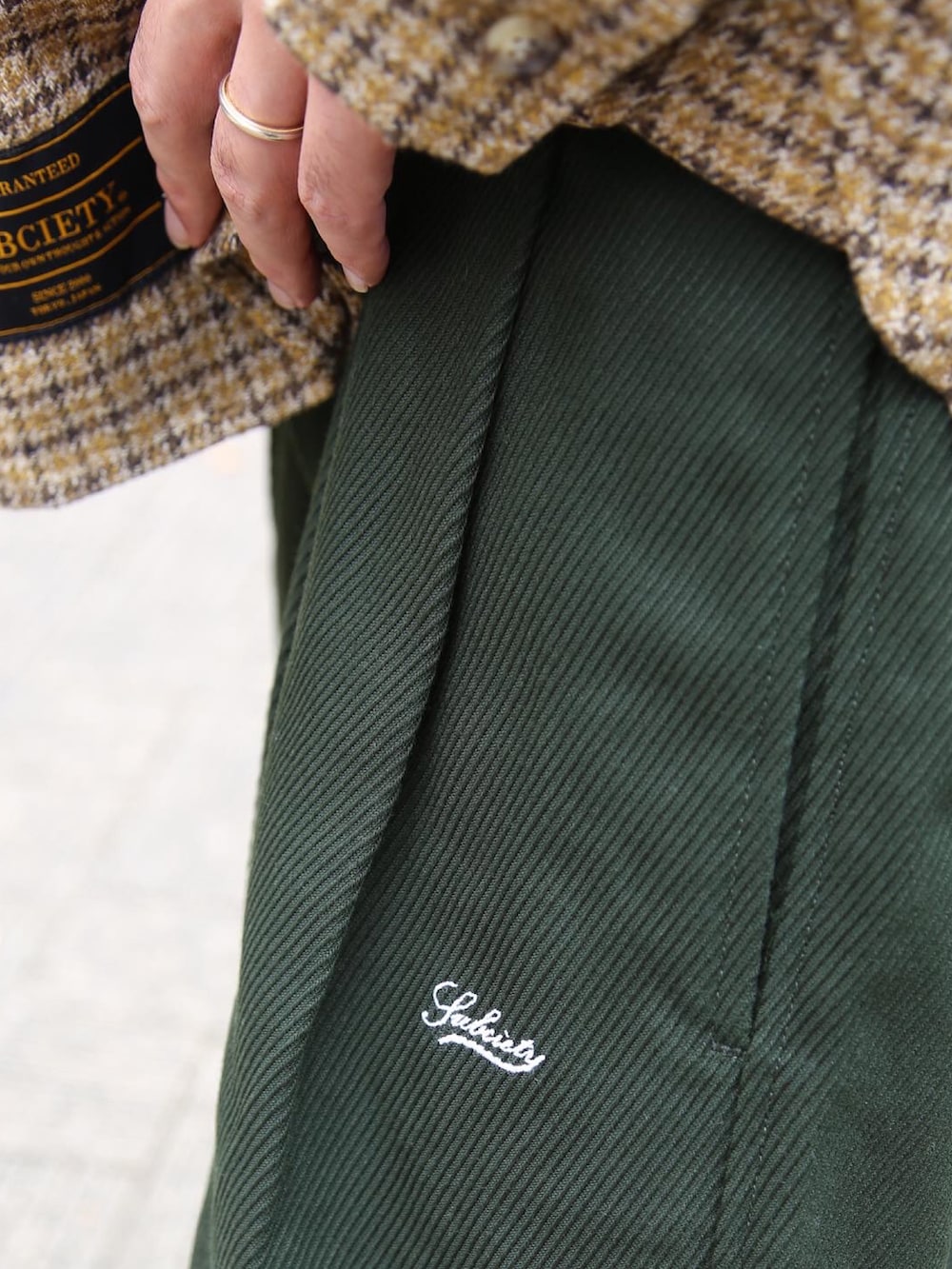 グリーン系のその他パンツ、イエロー系のシャツ/ブラウス、ブラック系のキャップを着用したメンズの秋コーディネートの3枚目の写真