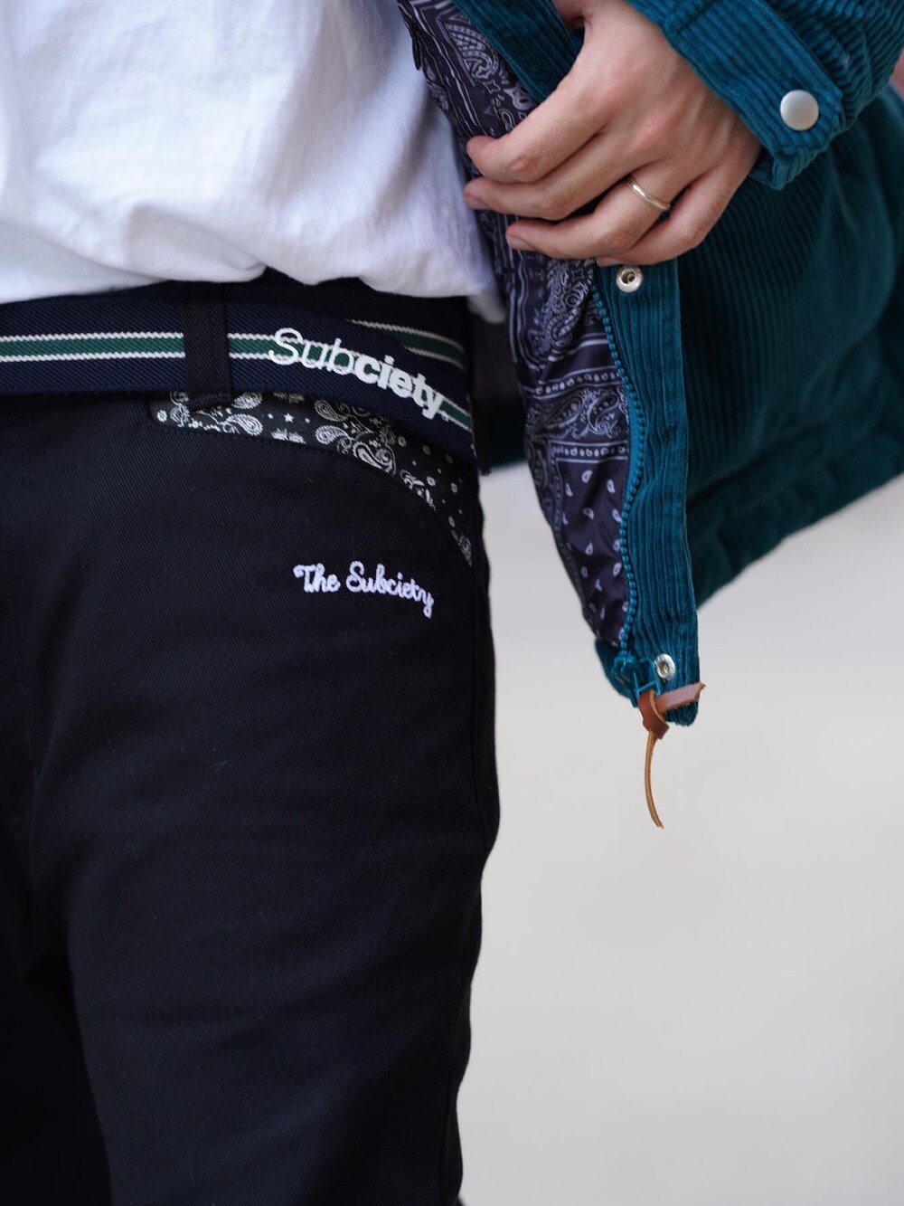 ブラック系のチノパンツ、ブルー系のダウンジャケット/コート、ブラック系のキャップを着用したメンズの秋コーディネートの3枚目の写真