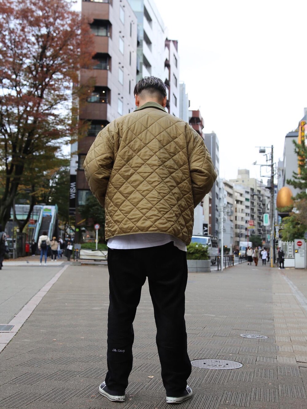 ブラック系のチノパンツ、グリーン系のミリタリージャケットを着用したメンズの秋コーディネートの2枚目の写真