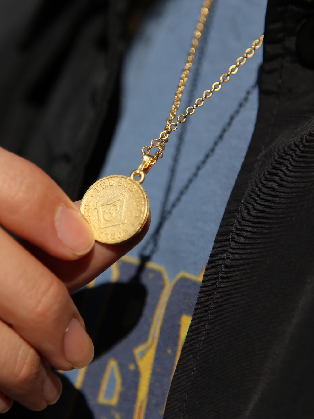 ゴールド系のネックレスを着用したメンズの冬コーディネートの2枚目の写真