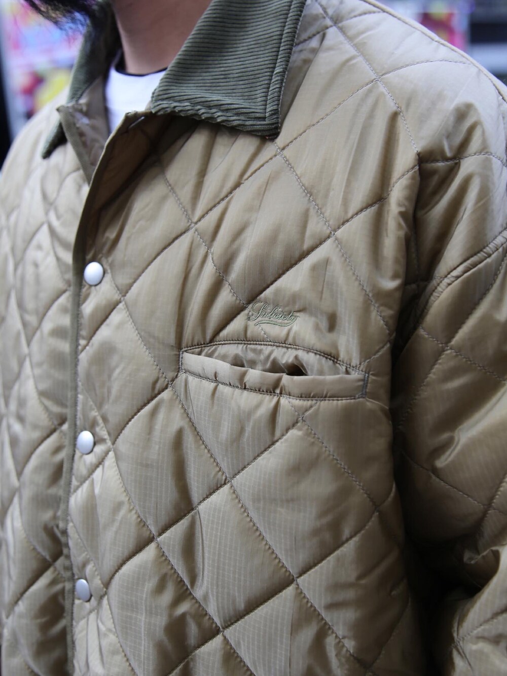 ブラック系のチノパンツ、グリーン系のミリタリージャケットを着用したメンズの秋コーディネートの3枚目の写真