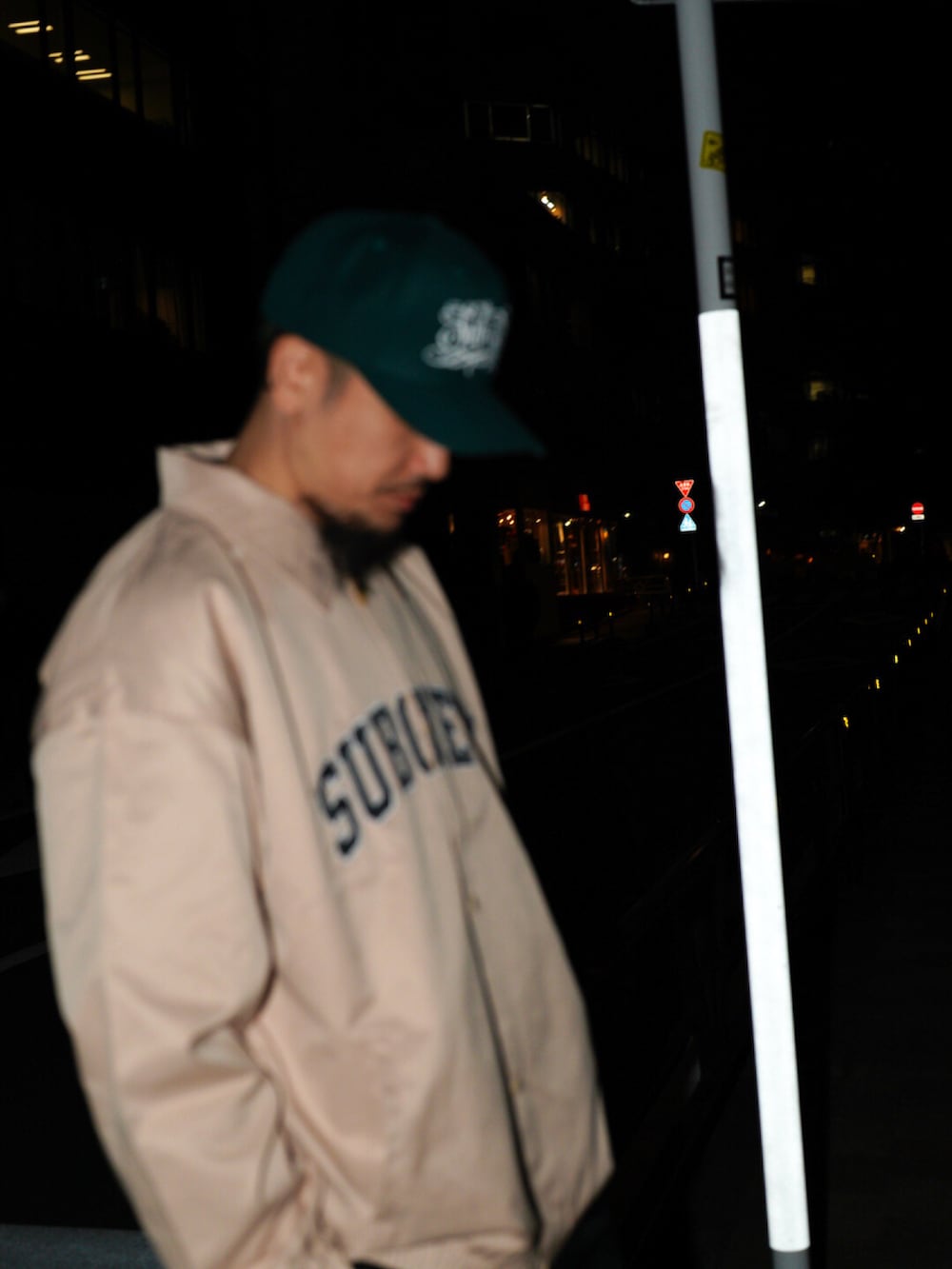 ベージュ系のブルゾン、グリーン系のキャップを着用したメンズの春コーディネートの2枚目の写真