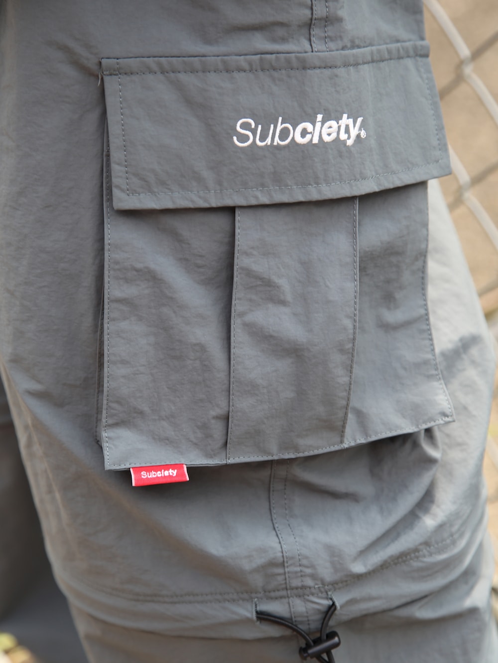 グレー系のカーゴパンツ、グリーン系のTシャツ/カットソー、シルバー系のネックレスを着用したメンズの夏コーディネートの3枚目の写真